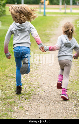 Deux jeunes filles courir main dans la main Banque D'Images