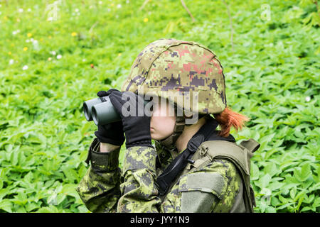 Portrait de femme armés avec camouflage. Jeune femme soldat observer avec des jumelles. Enfant soldat à canon dans la guerre, vert goutweed arrière-plan. Mili Banque D'Images