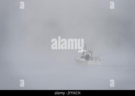 Bateau de pêche sur le lac dans un épais brouillard Banque D'Images