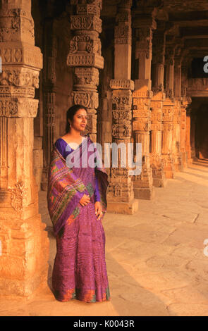 Femme en sari au milieu des piliers de grès sculpté complexe Qutb Minar, Delhi, Inde Banque D'Images