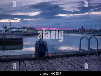 Un jeune homme d'admirer la dernière lumière du coucher du soleil à Québec, Canada par Quai Saint-andré Banque D'Images