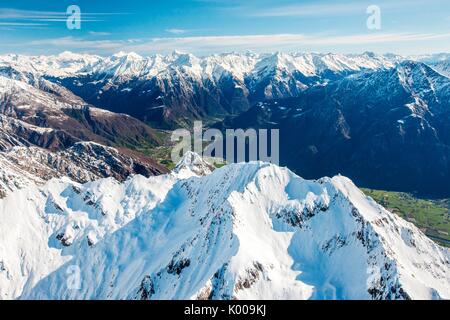 Vue aérienne de Sasso Canale couverte de neige avec Chiavenna derrière elle, Valchiavenna, Italie. Banque D'Images