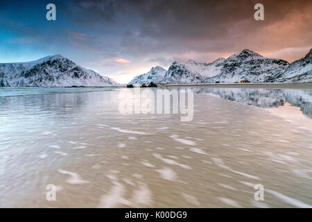 Ciel rose sur le surréel Skagsanden plage entourée de montagnes couvertes de neige. Îles Lofoten en Norvège du Nord Europe Banque D'Images