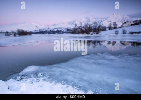 Sommets enneigés se reflètent dans le lac gelé Jaegervatnet au coucher du soleil des Alpes de Lyngen Stortind Tromsø Norvège Laponie Europe Banque D'Images