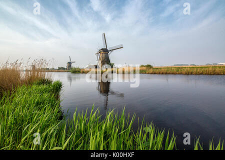 Les moulins à vent les trames de l'herbe verte reflétée dans le canal Kinderdijk Rotterdam Pays-Bas Hollande du Sud Europe Banque D'Images