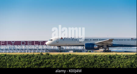 Delta Air Lines Boeing 757 avions de transport de passagers sur la piste de l'Aéroport International d'Atlanta en face du repère Fly Jets Delta en néon. (USA) Banque D'Images