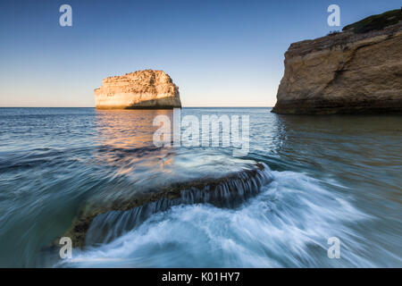 Les vagues de l'océan s'écraser sur les rochers au lever de Praia de Albandeira Caramujeira Carvoeiro Lagoa Algarve Portugal Europe Municipalité Banque D'Images