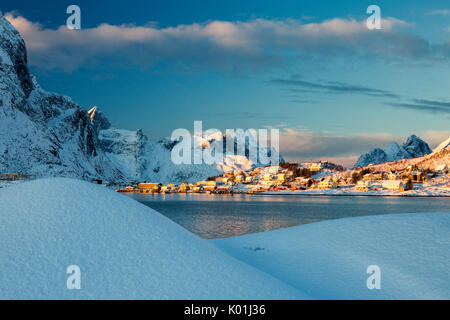 La couleur bleue du crépuscule sur le village de pêcheurs et les cimes enneigées d'Andøya Kvalvika Reine Nordland îles Lofoten Norvège Europe Banque D'Images