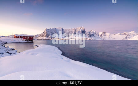 Les couleurs de l'aube les cadres de maisons de pêcheurs entouré par la mer gelée Sakrisøy Reine Nordland îles Lofoten Norvège Europe Banque D'Images