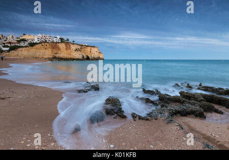 Les vagues de l'océan s'écraser sur les rochers et la plage entourant le village de Carvoeiro Lagoa au coucher du soleil de l'Algarve Portugal Europe Municipalité Banque D'Images