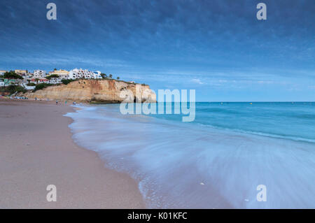 Les vagues de l'océan s'écraser sur les rochers et la plage entourant le village de Carvoeiro Lagoa au coucher du soleil de l'Algarve Portugal Europe Municipalité Banque D'Images