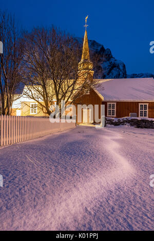 Lumières sur l'église en bois typique entouré de neige Flakstad Lofoten, Norvège du Nord Europe Banque D'Images