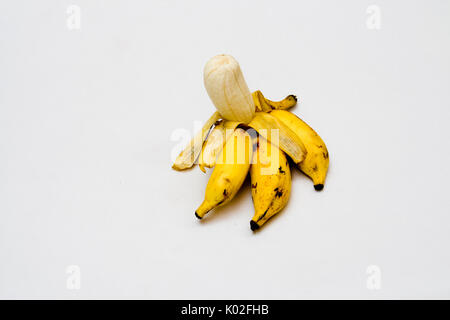 Bananes pelées appétissant enveloppés dans des peaux de couleur jaune doré, isolé en blanc chargé sur 27jul17accepté Banque D'Images