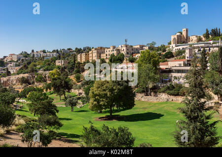 Vue sur pelouse verte et arbres de Zurich jardin comme arrière-plan sur les maisons typiques à Jérusalem, Israël. Banque D'Images