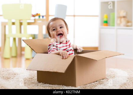 Joli bébé Bébé garçon assis à l'intérieur de la boîte Banque D'Images