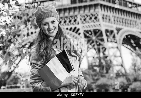 Escapades d'Automne à Paris. souriante jeune femme élégante sur le quai à Paris, France avec le drapeau Banque D'Images