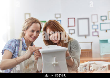 Les femmes artistes peinture banc en bois dans la classe d'art atelier Banque D'Images