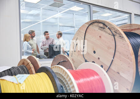 Les superviseurs talking in office derrière tiroirs dans la fibre optique factory Banque D'Images