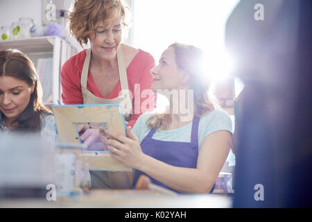 Aider les élèves à l'instructeur féminin cadre photo peinture dans la classe d'art atelier Banque D'Images