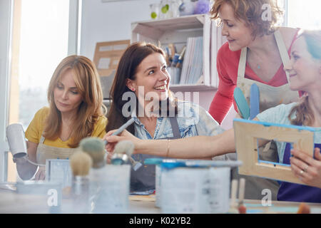 Instructeur féminin aide les étudiants et les cadres de peinture dans la classe d'art atelier Banque D'Images