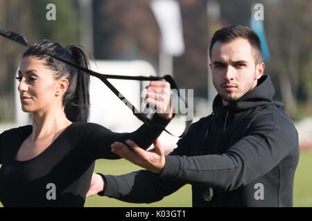 Ce beau couple avec sangles Fitness Crossfit Trx dans City Park - formation et l'exercice d'endurance - Style de vie sain en plein air Concept Banque D'Images