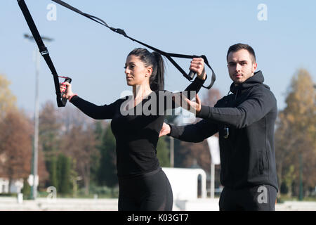 Ce beau couple avec sangles Fitness Crossfit Trx dans City Park - formation et l'exercice d'endurance - Style de vie sain en plein air Concept Banque D'Images