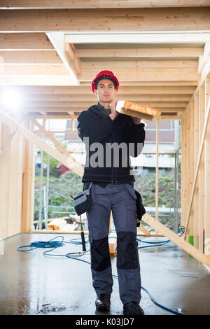 Carpenter Réalisation Plank at Construction Site Banque D'Images