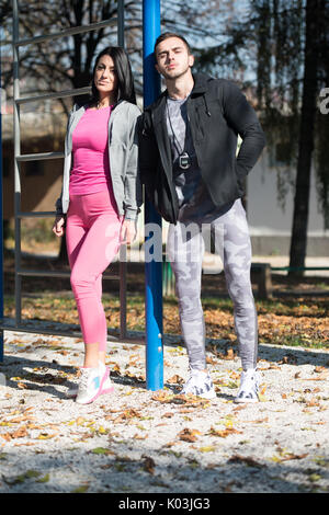 Couple remise en forme forte dans City Park - Bodybuilder Model Posing athlétique musculaire exercices après Banque D'Images