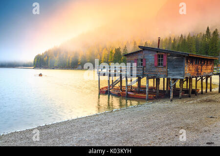 Automne spectaculaire paysage brumeux, magnifique ancienne en bois dock house sur le lac avec des bateaux en bois, lac de Braies, Dolomites, Italie, Europe Banque D'Images