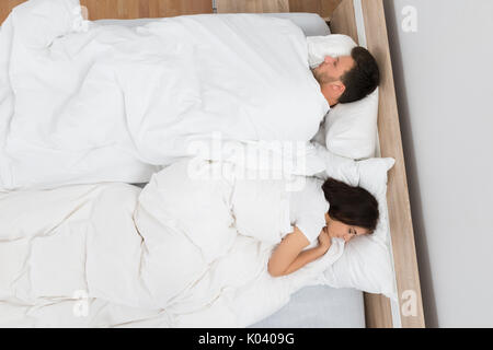 High Angle View of Young Couple Sleeping On Bed Banque D'Images