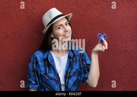 Happy girl Playing with fidget spinner. Portrait of young woman holding spinner. La mode populaire, le Toy Banque D'Images