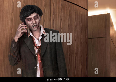 Portrait de creepy asian zombie man in suit appel via cellphone Banque D'Images