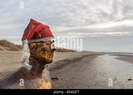 Statue de Crosby avec chapeau de Santa surplombant la plage - Sculpture de Sir Anthony Gormley Banque D'Images