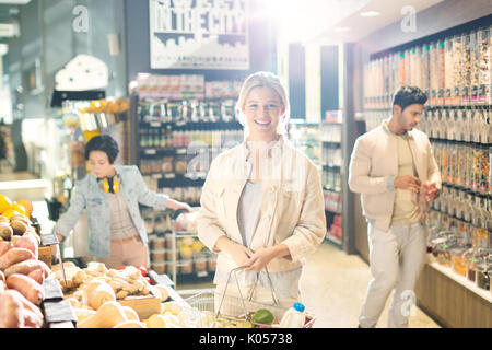 Portrait of smiling young woman grocery shopping in market Banque D'Images