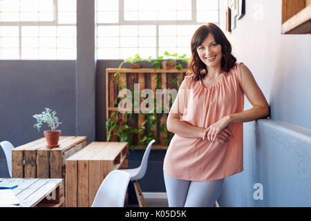 Smiling young office worker Standing alone in a modern office Banque D'Images