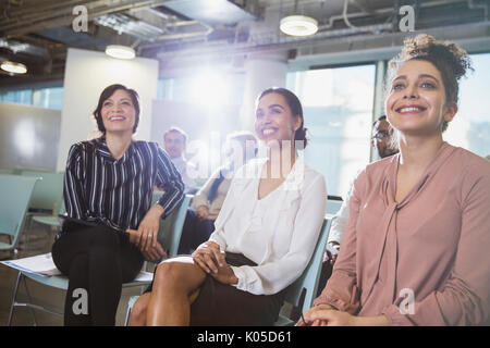 Smiling businesswomen écoute en séance Banque D'Images