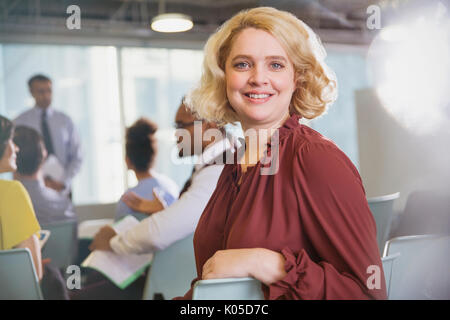 Confiant, Portrait smiling businesswoman in conference audience Banque D'Images