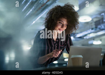 Businesswoman travaillant tard at computer in office Banque D'Images