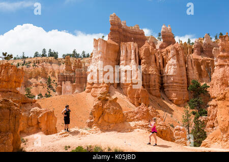 Les touristes prenant des photos parmi les formations de roche résumé dans le parc national de Bryce Canyon dans l'Utah, USA. Banque D'Images