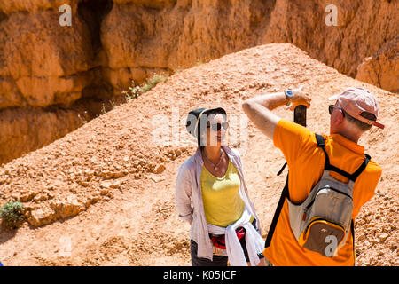 Les touristes prenant des photos parmi les formations de roche résumé dans le parc national de Bryce Canyon dans l'Utah, USA. Banque D'Images