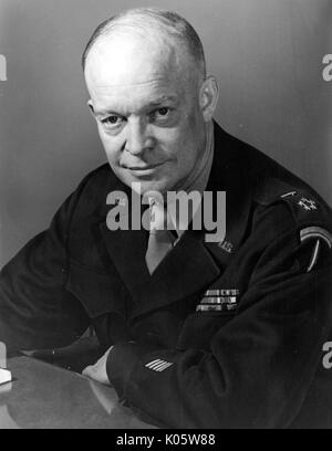 Portrait de mi-longueur de Dwight Eisenhower, assis avec les bras s'appuyant sur une table, avec une expression du visage grave, vêtu de noir chemise militaire, 1945. Banque D'Images