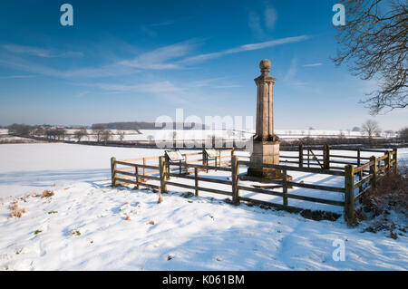 Cromwell Monument dans la neige à la bataille de Naseby site regardant vers les arbres de long Hold Spinney sur Dust Hill, Naseby, Northamptonshire, Angleterre. Banque D'Images