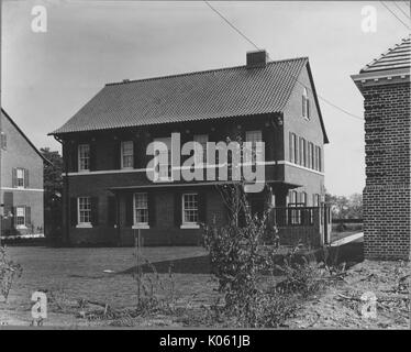 Photo de paysage de l'arrière-cour d'une maison en brique de deux étages avec des fenêtres blanches et arche volets aux fenêtres, deux autres maisons en briques de chaque côté de la chambre, la rareté de l'aménagement paysager de l'arrière-cour, Roland Park/Guilford, United States, 1910. Cette image est tirée d'une série sur la construction et la vente de maisons dans le quartier Roland Park/Guilford de Baltimore, a streetcar suburb et l'une des premières communautés planifiées aux États-Unis. Banque D'Images