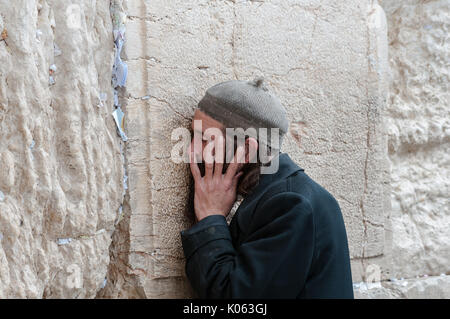 Un homme juif devoutely prie à Dieu au Mur occidental. Banque D'Images