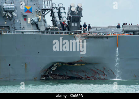 Singapour, Singapour. Août 21, 2017. La marine américaine de la classe Arleigh Burke destroyer lance-missiles USS John S. McCain avec dommages à la coque bâbord du quai à la base navale de Changi pour des réparations d'urgence le 21 août 2017 à Singapour. Le navire est entré en collision avec le navire marchand civil Alnic MC pendant qu'ils sont en cours à l'est du détroit de Malacca causant des dégâts importants et 10 marins portés disparus et présumée morte. Credit : Planetpix/Alamy Live News Banque D'Images