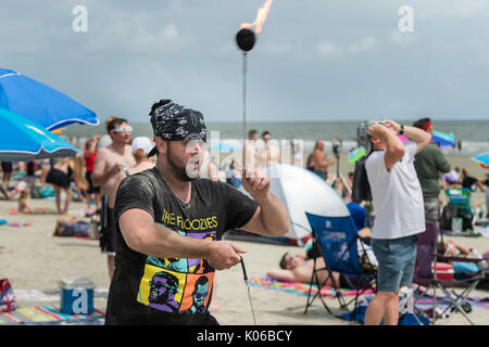 Charleston, Isle of Palms, USA. Août 21, 2017. Un homme tournoie comme des boules de l'éclipse totale passe au-dessus de la plage à l'extérieur de Charleston, 21 août 2017 à Isle of Palms, Caroline du Sud. L'éclipse solaire, après avoir balayé tout le pays traverse la région de Charleston avant de partir sur l'océan Atlantique. Credit : Planetpix/Alamy Live News Banque D'Images