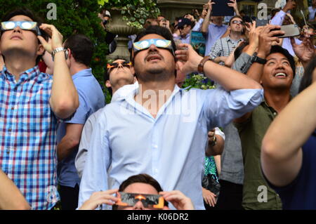 Une foule de New-Yorkais enfilent leurs lunettes solaires pour voir en toute sécurité l'éclipse solaire à Bryant Park à Manhattan Banque D'Images