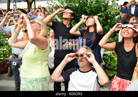 Les New-Yorkais enfilent leurs lunettes solaires pour voir l'éclipse solaire à Bryant Park à Manhattan lors d'un événement astronomique rare Banque D'Images