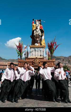 Les paroissiens se pencher sous le poids d'une statue de Saint Jacques comme ils mener à Plaza de Armas pendant les festivités du Corpus Christi, Cusco, Pérou. Banque D'Images