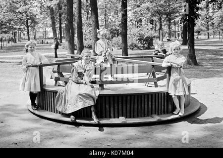 Les enfants qui passent un rond-point à Merry-Go-round à Clark Park, D. Banque D'Images